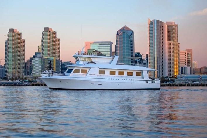 The Zolna Yachts&rsquo; Nerissa on calm water at sunset with San Diego skyline in background..