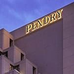 Exterior of a modern building with the illuminated "Pendry" sign against a blue sky.