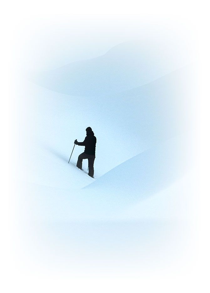 silhouette of a man with hiking pole climbing a big snow bank